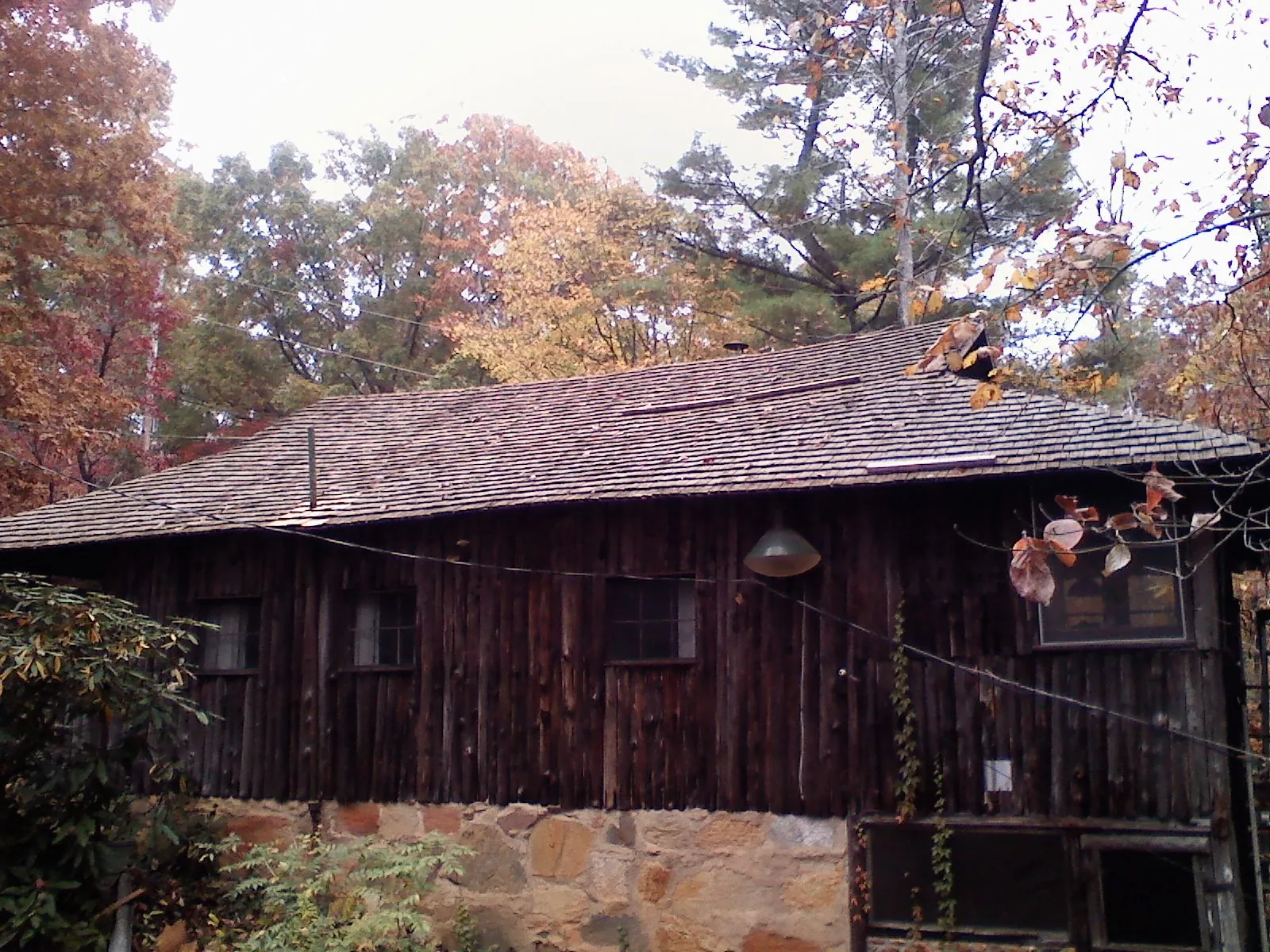 Weathered wood shake roof on a rustic board sided cabin in Staffordsville