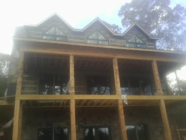 Dormers and porch framing on a large log home under construction — Roof Coating work by our crew in Staffordsville
