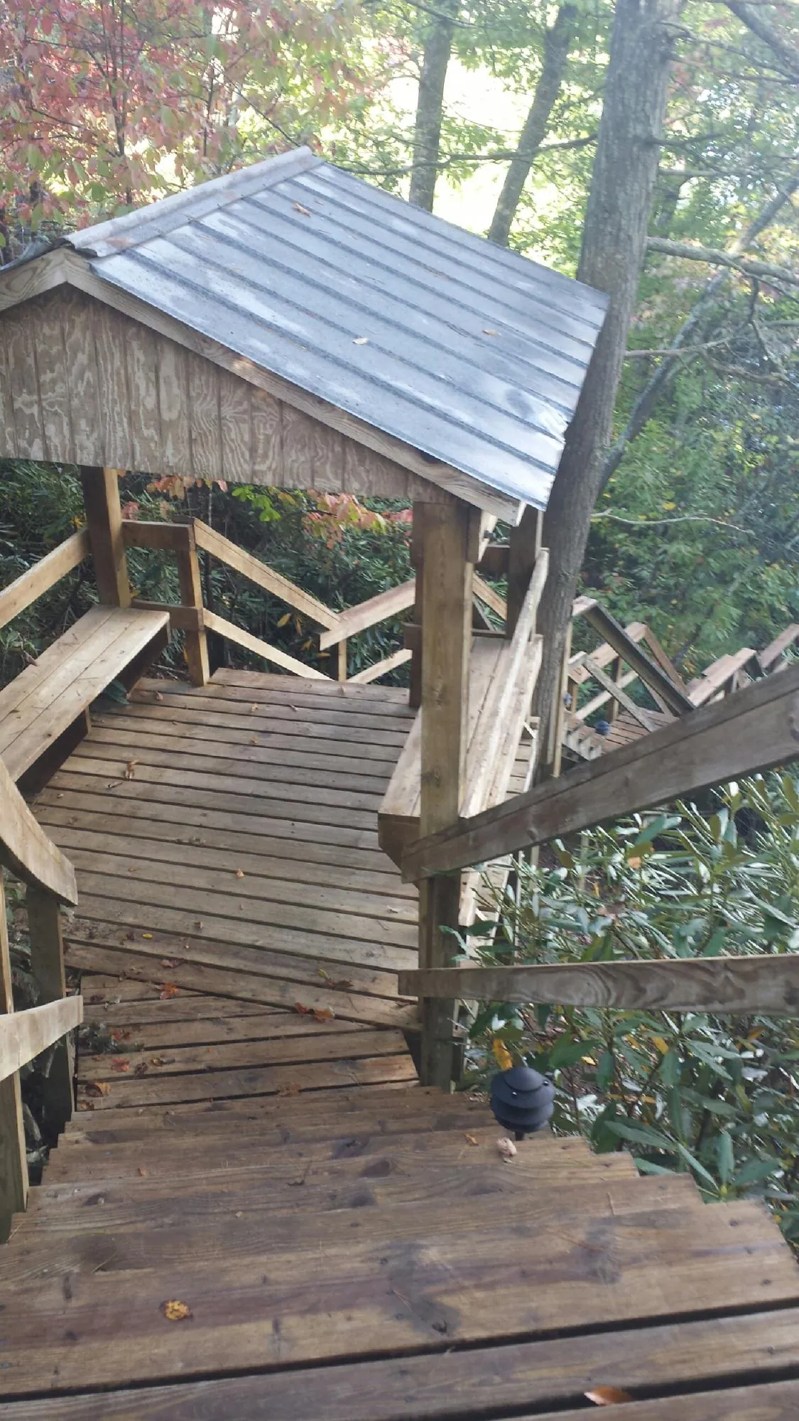 Metal roofed shelter over wooden steps on a wooded walkway — Skylight Repair & Installation work by our crew in Staffordsville